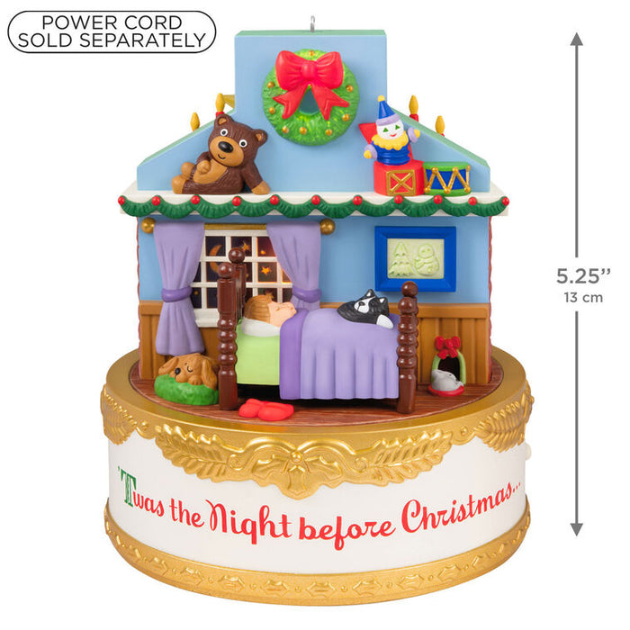 Decorative Christmas village scene with a house, bed, and characters, featuring measurements and a power cord sold separately text.