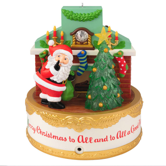 Decorative Christmas ornament with Santa Claus, tree, and fireplace.