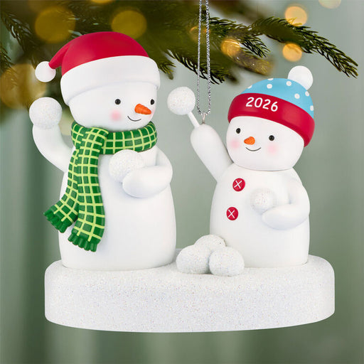 Two snowman ornaments with festive hats and scarves on a decorative base.