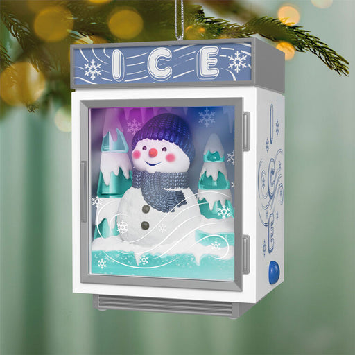 Decorative ornament resembling an ice freezer with a snowman design on a green background.