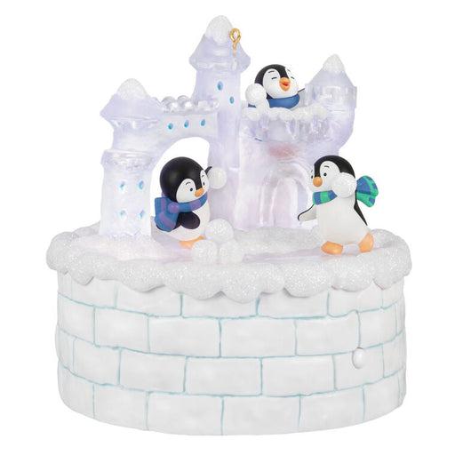 Decorative ice castle ornament with penguins on a white background