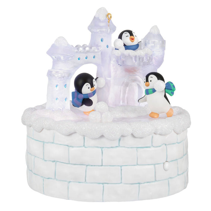 Decorative ice castle ornament with penguins on a white background