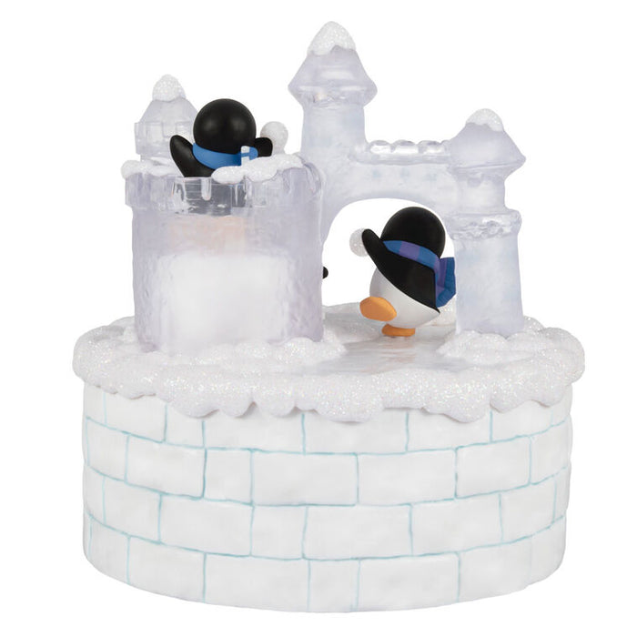 Decorative ice sculpture castle with penguins on a white background