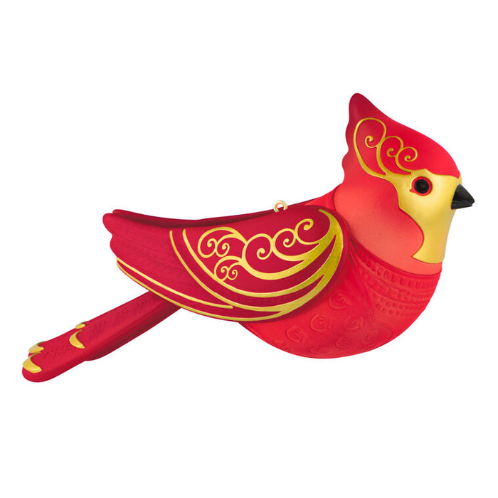 Red and gold cardinal ornament on a white background