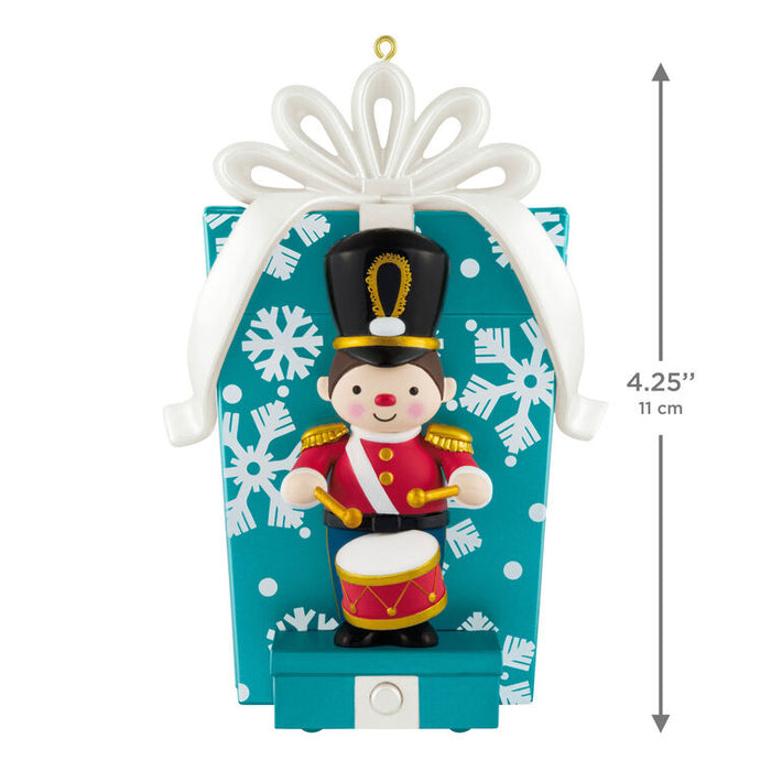 Christmas ornament of a toy soldier with drum on a decorative box, showing measurements.