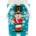 Christmas-themed figurine of a drummer boy on a decorative card with snowflakes.
