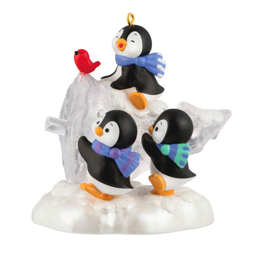 Ornament with penguins and a bird on a snowy base with an ice sculpted tree