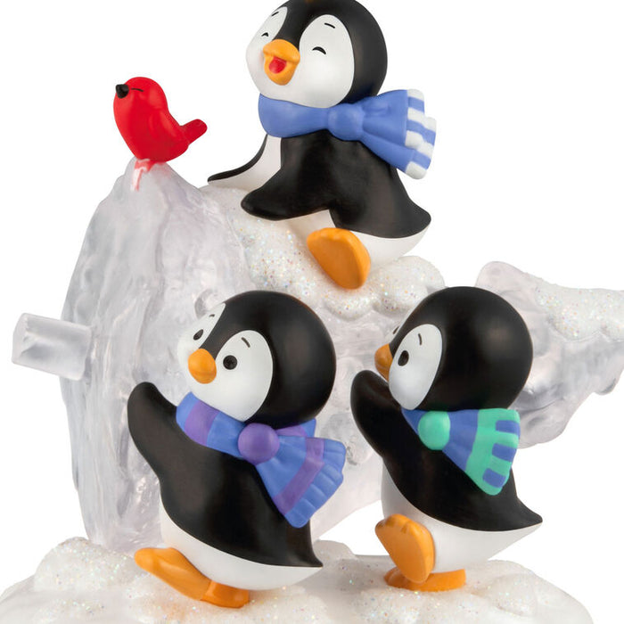 Set of penguin figurines with colorful scarves and a red bird on a white background