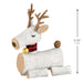 Decorative reindeer figure made of logs with antlers, a bell, and a pine cone on a white background.