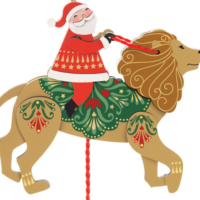 Decorative figure of Santa Claus riding a lion with Christmas-themed decorations on a white background.