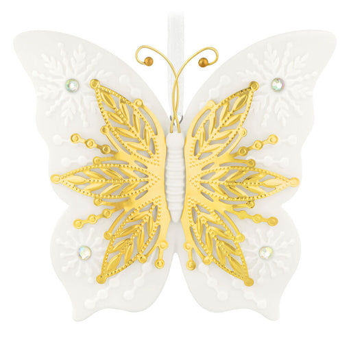 Butterfly-shaped decorative ornament with gold and white design on a white background