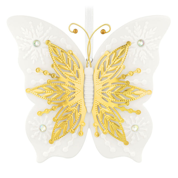 Butterfly-shaped decorative ornament with gold and white design on a white background