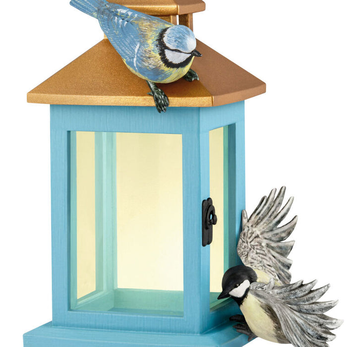 Blue birdhouse with two birds on a white background