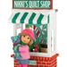Decorative ornament of a girl with a teddy bear in front of 'Nikki's Quilt Shop'.
