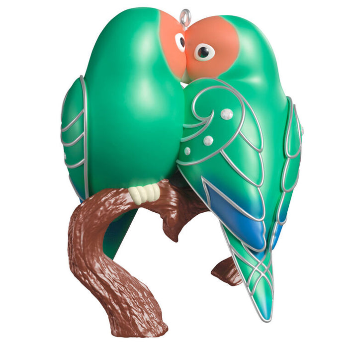 Decorative ornament of two green birds on a branch with a white background
