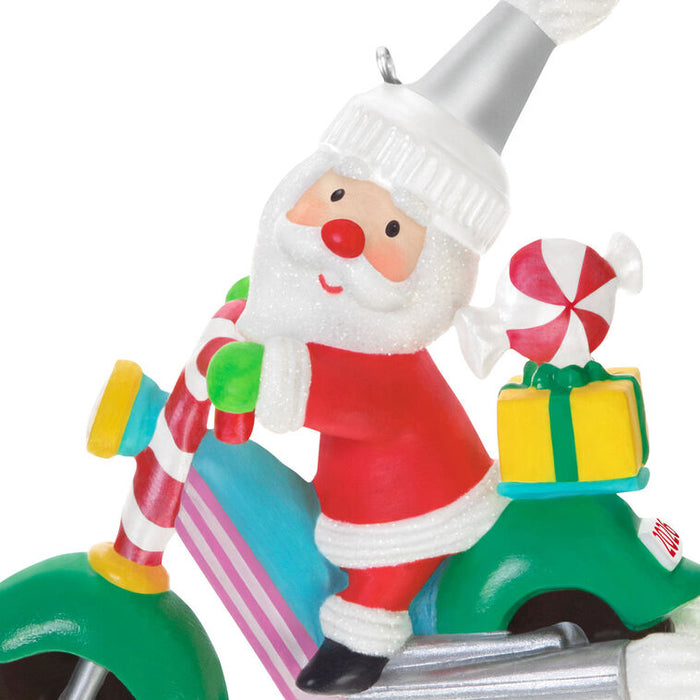 Decorative ornament of Santa Claus on a motorcycle with candy and gifts.