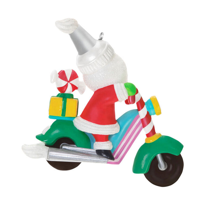 Christmas ornament of Santa Claus on a motorcycle with candy cane details.