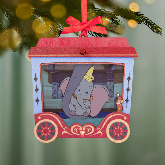Decorative ornament with Dumbo and Mrs. Jumbo in a designed cutout, featuring a red ribbon on top, hanging from a tree