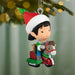 Christmas ornament of a elf with a horse toy and elf hat hanging on a tree.