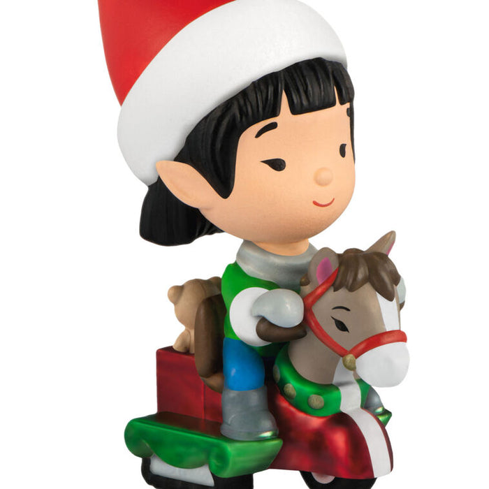 Figurine of a elf in an elf hat riding a horse toy on a white background