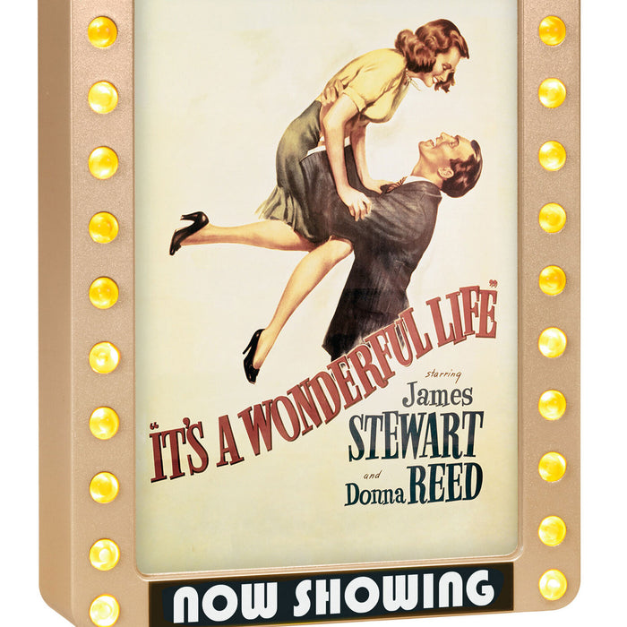 Vintage movie poster for 'It's a Wonderful Life' with a couple embracing, framed by light bulbs.