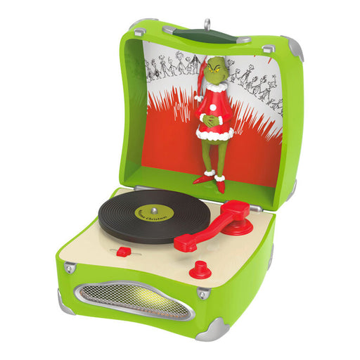 Toy record player with the Grinch in a Santa outfit on a white background