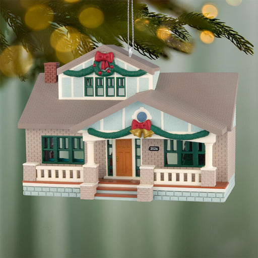 Christmas ornament of a house with decorations on a green background