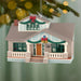 Christmas ornament of a house with decorations on a green background