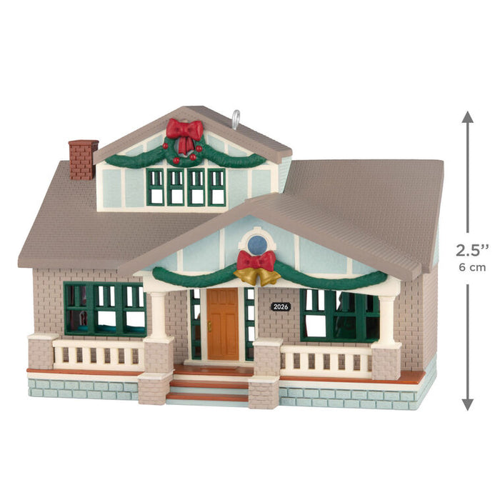 Model of a decorated house with Christmas ribbons and a small size indicator on a white background