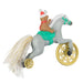Decorative ornament of a toy pony with wheels and a teddy bear rider wearing a Santa hat on a white background.