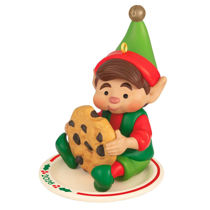 Elf figurine holding a cookie on a white background