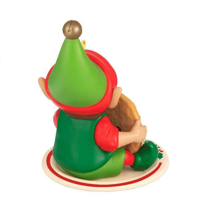Christmas elf figurine with green hat and red shirt on a white background
