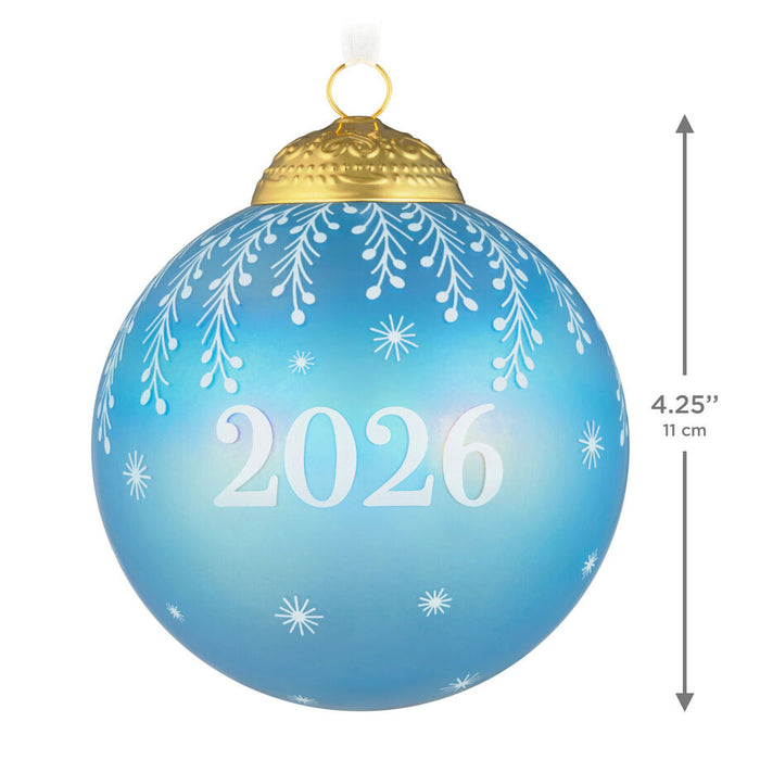 Blue Christmas ornament with '2026' and snowflake patterns, gold top, on a white background.
