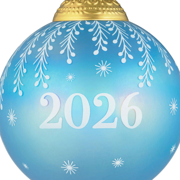Blue ornament with '2026' and snowflake patterns on a white background