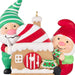 Decorative ornament with two elves and a gingerbread house on a white background