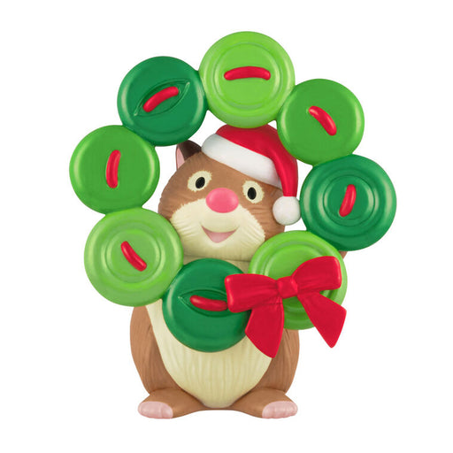 Hamster character wearing a Santa hat and surrounded by green wreath made of buttons with red ribbons on a white background