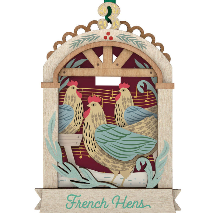 Decorative ornament with chickens and the text 'French Hens' on a white background