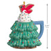 Decorative Christmas ornament of tree-shaped mug with a swirl of whipped cream and sparkles and topped with a cardinal cookie on top, featuring dimensions on a white background.