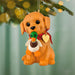 Dog-shaped Christmas ornament with a duck toy in its mouth, hanging on a tree.