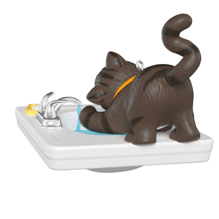 Decorative ornament of a cat on a sink on a white background