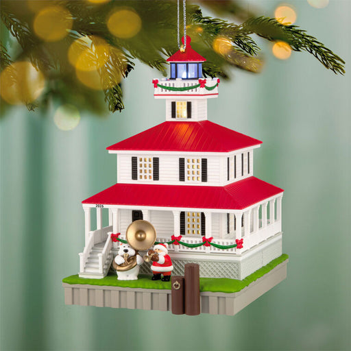 Decorative lighthouse ornament with Santa Claus and a polar bear on a green background