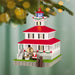 Decorative lighthouse ornament with Santa Claus and a polar bear on a green background