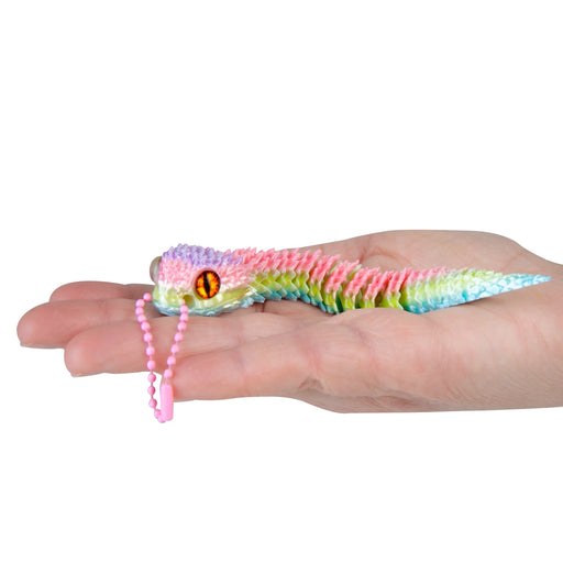 Colorful toy lizard on a person's hand against a white background