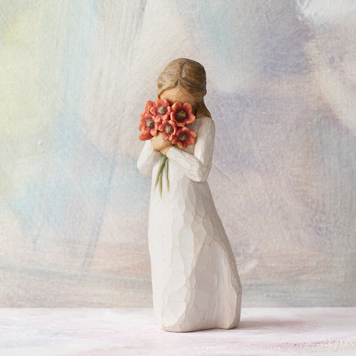Statue of a woman holding flowers against a textured white background