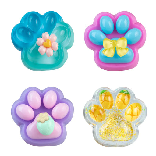 Four colorful paw-shaped accessories arranged in a 2x2 grid on a white background. The top-left piece is translucent teal with a small pink flower in the center.