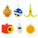 Six Nintendo-themed plush character ornaments hanging from white strings on a plain white background, including an orange mushroom, blue shell, banana peel, red camera, white squid, and gold coin.