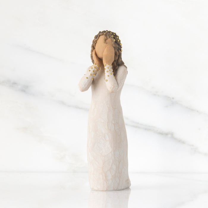 Decorative figurine of a woman with braided hair and a white dress on a marble background