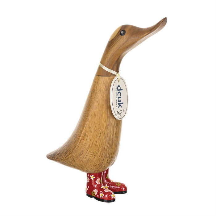 Wooden duck figurine with red boots and a tag on a white background