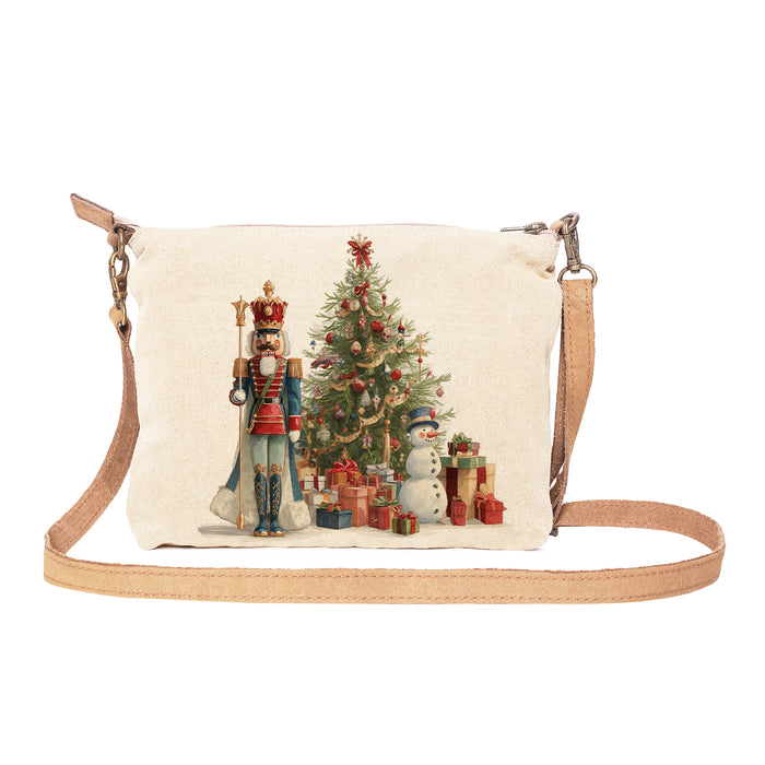 Canvas crossbody bag with Christmas design featuring a nutcracker, tree, and snowman on a white background.