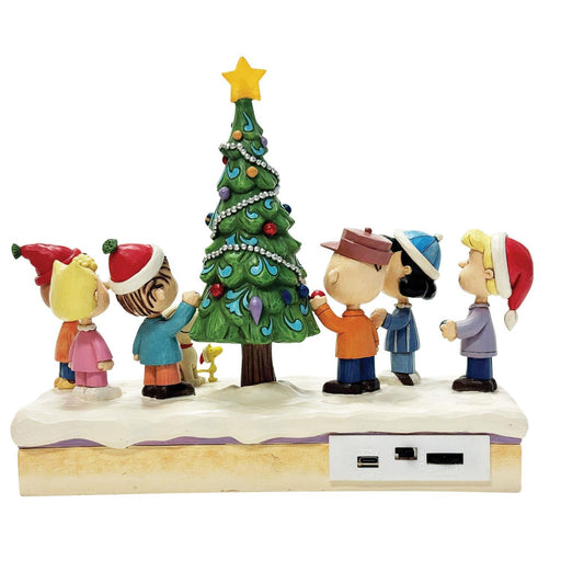 Figurine of children around a Christmas tree with USB charging ports on a white background